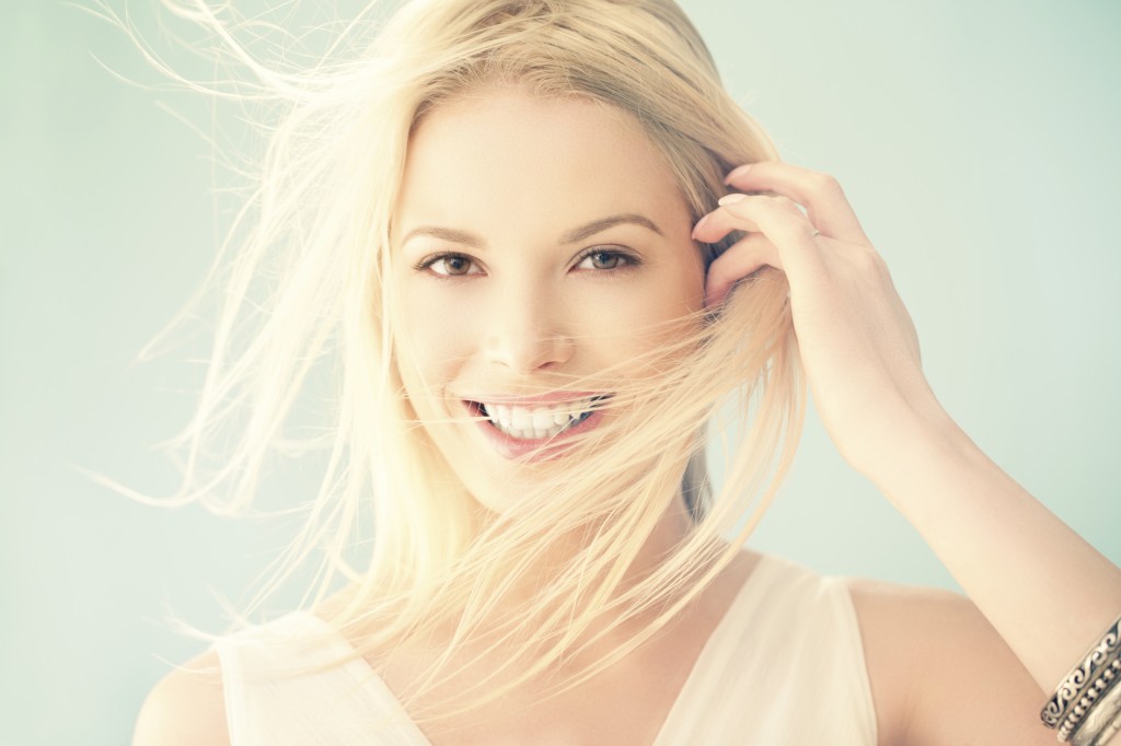 Image of a woman brushing her hair behind her ear