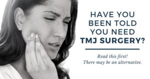 A woman holding her painful jaw and needing TMJ Treatment.