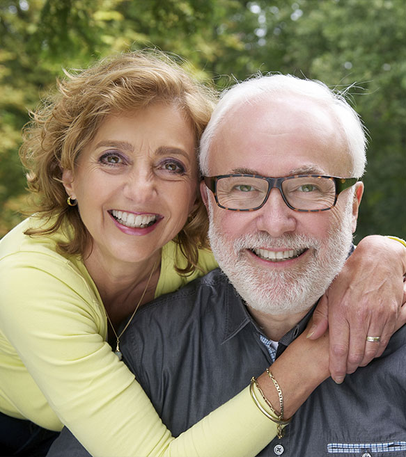Middle-aged couple hugging and smiling in a park