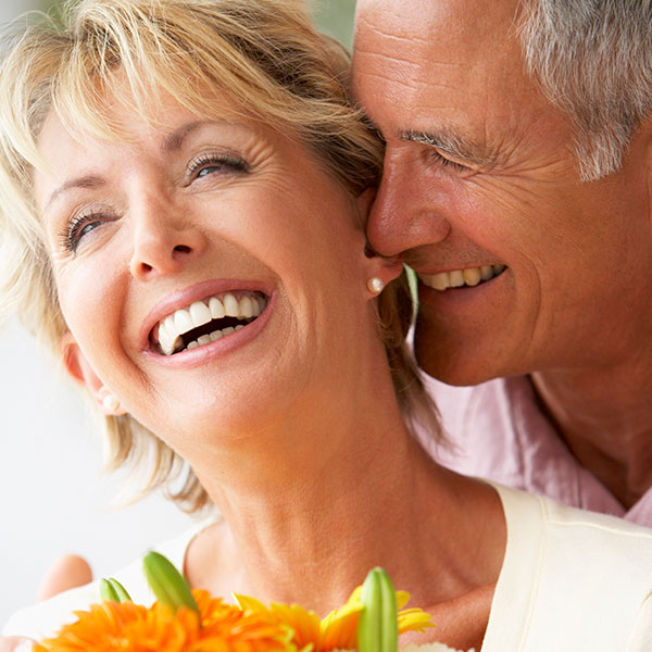 Smiling couple with natural looking dental implants